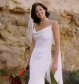 Ivory cowl necked Marocain silk dress.<br><br>
		Bias cut low V-back dress with glass and pearl bead detailing. 
		Shoestring straps, shoulder sail and Arum lily train with hand-rolled finish.